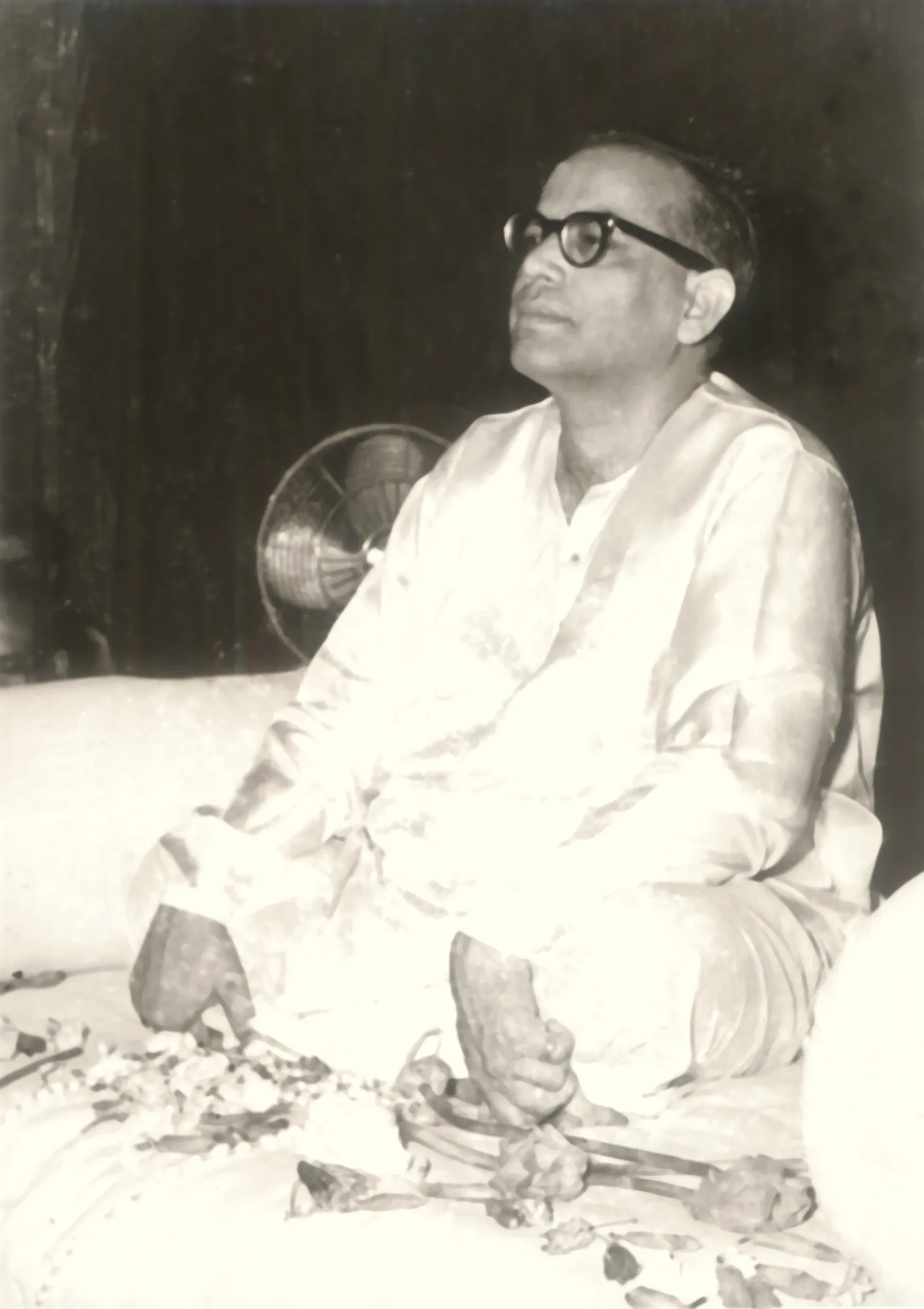 Shrii Shrii Anandamurti seated, holding a hand fan