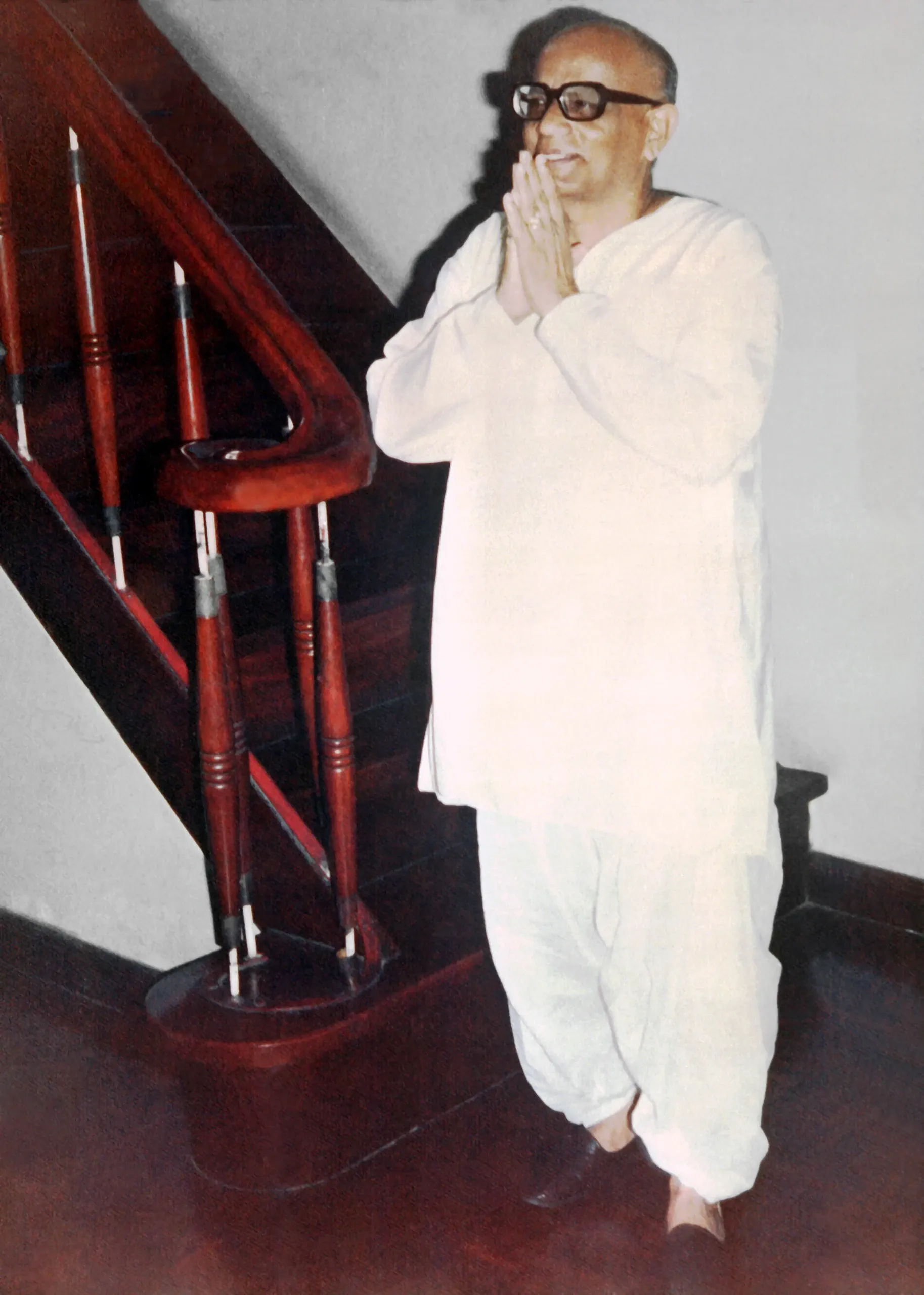 Shrii Shrii Anandamurti with folded hands on a staircase