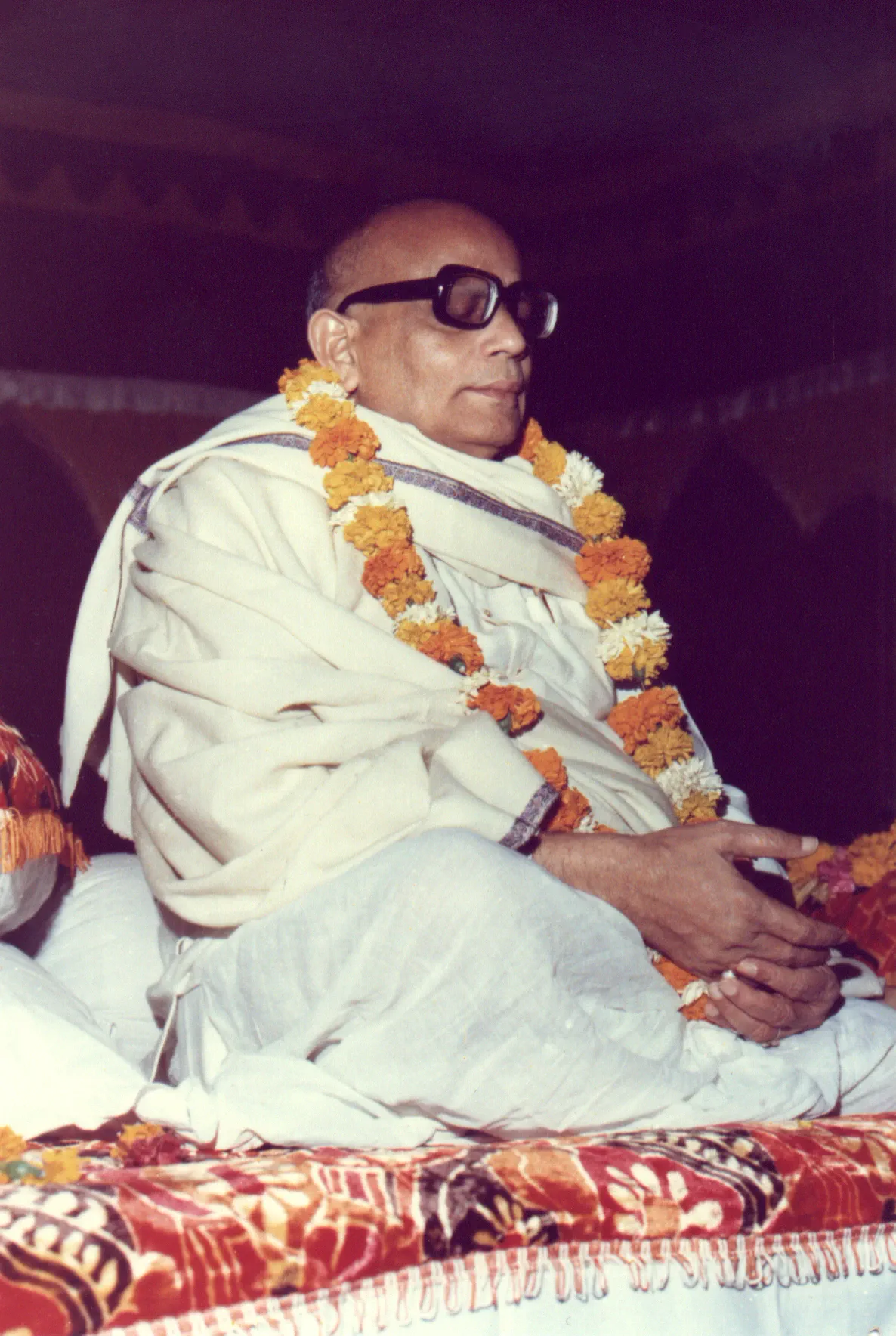 Shrii Shrii Anandamurti garlanded on a dais