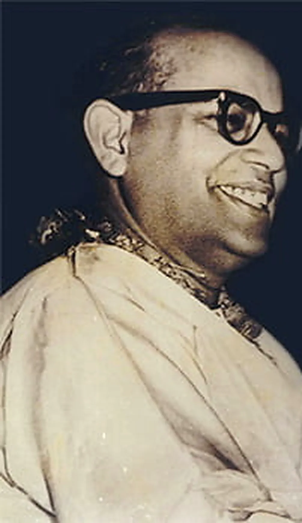 Shrii Shrii Anandamurti smiling, wearing a garland of flowers